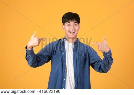 Choose An Pick Me. Confident Young Man Pointing And Promoting Himself. Portrait Asia Young Man Isola