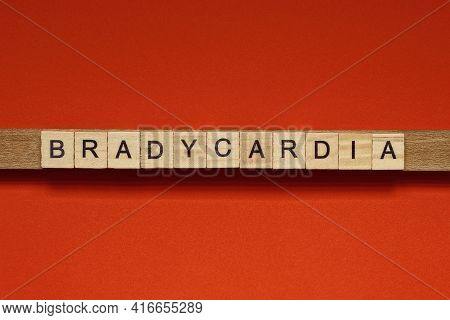 Text The Word Bradycardia From Gray Wooden Small Letters With Black Font On An Red Table