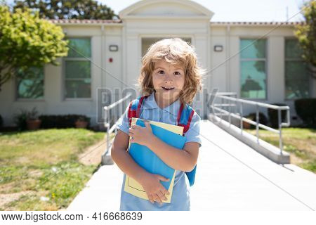 Child With Rucksacks Standing In The Park Near School. Pupils With Books And Backpacks Outdoors. Kid