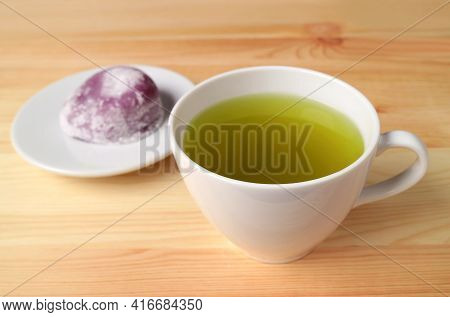 Closeup A Cup Of Japanese Green Tea With Blurry Purple Sweet Potato Daifuku Or Red Bean Paste Fillin