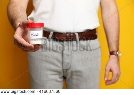 Donor Holding Container With Sperm On Yellow Background, Closeup