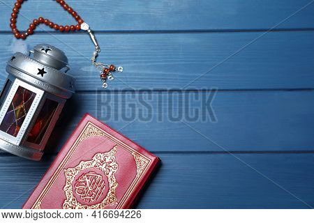 Arabic Lantern, Quran And Misbaha On Blue Wooden Table, Flat Lay. Space For Text