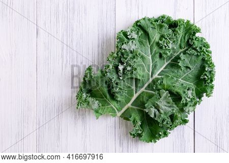 Kale Leaf Pread Out On A Wooden Surface. Super Food Concept, Healthy And Vegetarian Food. Selective 