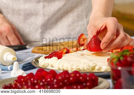 Woman Baker Stacks Strawberries On Meringue Strawberry Cake Base. Homemade Strawberries Cake Made Fr
