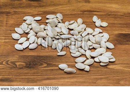 Pumpkin Seeds On A Wooden Table. Quality Photo