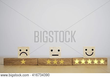 Customer Satisfaction Survey Concept, Human Face Icons And Yellow Stars Print Screen On Wooden Cube 