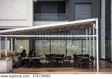 Belgrade, Serbia - April 3, 2021: Selective Blur On Three Girls Sitting  On Empty Terrace And Patio 