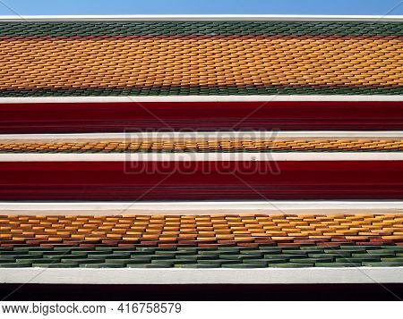 three layered roof, colorful clay tiles fish scales or repeated wave pattern with red wooden eaves of thai temple or ancient grand palace with blue sky, Asian art traditional exterior architecture