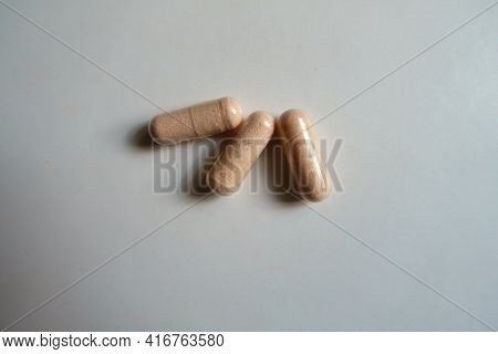 3 Pink Capsules Of Probiotic Dietary Supplement From Above