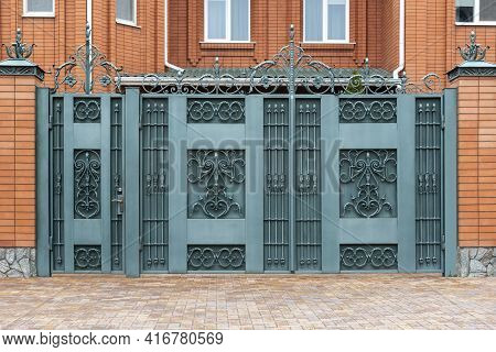 Wrought Iron Gates With Doors. Facade Of The House.