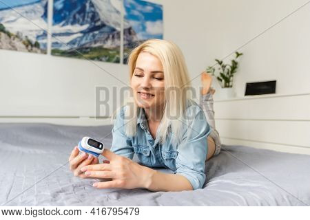Woman Patient Using Medical Device Called Finger Pulse Oximeter. From Below, Close-up. Unrecognizabl
