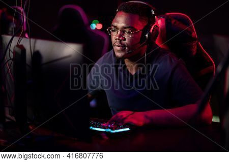 An African Guy Wearing Headphones And Glasses Leads An Online Stream During The Computer Games Champ