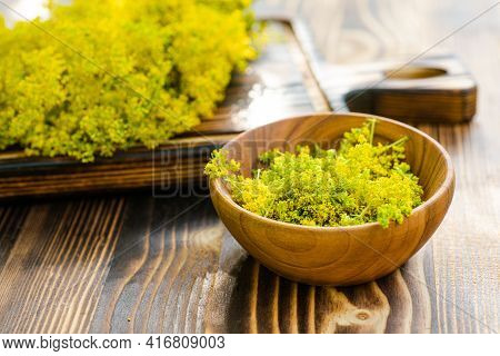Galium Verum, Lady Bedstraw Or Yellow Bedstraw Used In Alternative Medicine In Wooden Plate On A Vin