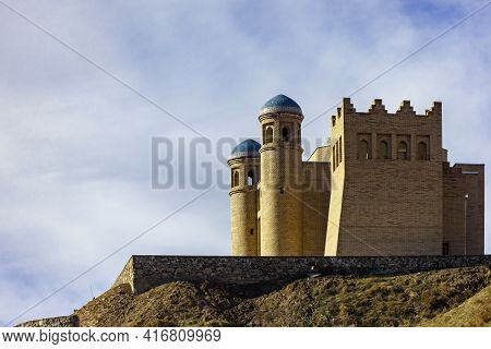An Ancient Fortress On A Hillside Against The Sky In The Mountains. Old Historical Defensive Structu