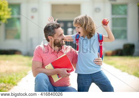 Father Leads A Little Child School Boy In First Grade. School, Family, Education And Outdoor Concept