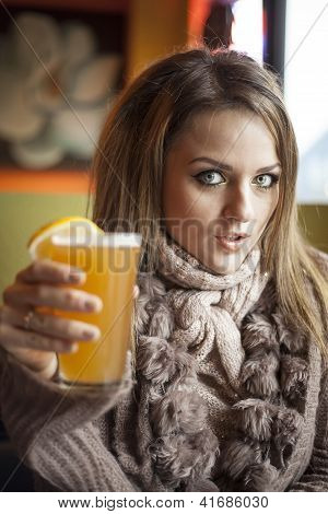 Mladá žena s nádherně modré oči pití Hefeweizen pivo