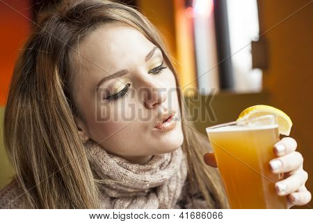 Mladá žena s nádherně modré oči pití Hefeweizen pivo
