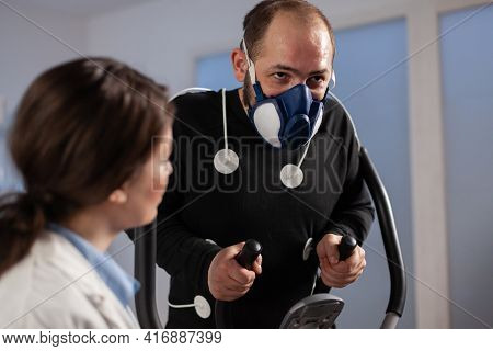Fitness Researcher Monitoring Performance Athlete With Sensors