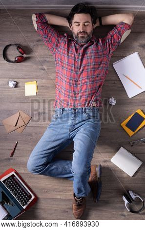 Man relaxing on floor thinking idea solitions. Student man lying top view. Creative inspiration study concept