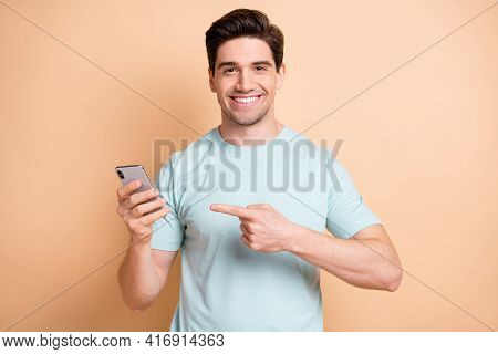 Portrait Of Attractive Cheerful Guy Influenzer Demonstrating Device Media Feedback Isolated Over Bei