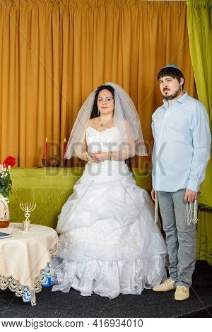 Jewish Bride And Groom In The Synagogue Stand In Front Of Chupa During The Ceremony. Vertical Photo
