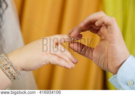 The Groom Putting The Bride On The Index Finger On The Jewish Wedding Hand Close-up. Horizontal Phot