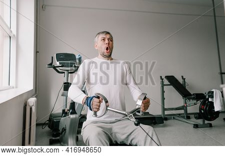 A Man With A Tense Face Performs Strength Training In The Gym. Chest Cravings. Intensive Training