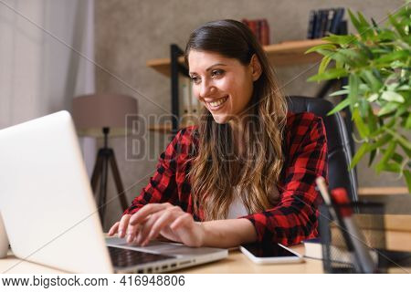 Woman Teleworker Works At Home With A Laptop