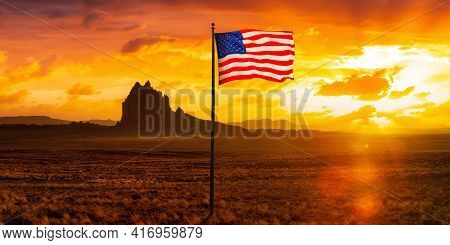American National Flag Composite In Dry Desert With A Mountain Peak In The Background. Colorful Suns