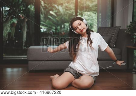Woman With Headphones And Smartphone Stretch Oneself Or Stretched Lazily For Relaxation On Floor In 
