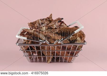 Shopping Basket With Dog Treats On A Pink Background. Natural Treats In A Metal Basket. Dried Beef L