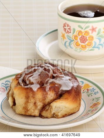 Roll cynamonem i filiżankę kawy
