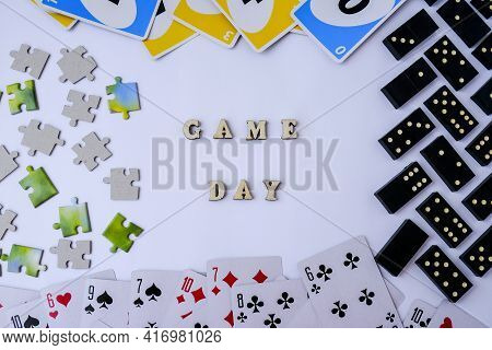 Kiev, Ukraine - 10.03.2021 Text Game Day. Dominoes Puzzles Playing Cards Around. The Concept Of Rela