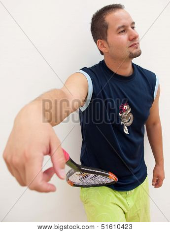 Squash player leans racket