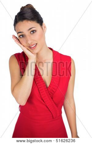 Worried sexy brunette in red dress posing on white background