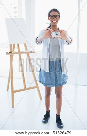 Smiling attractive artist taking picture in bright room