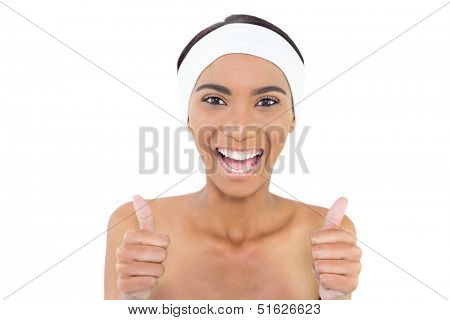 Smiling gorgeous model wearing headband giving thumbs up to camera on white background