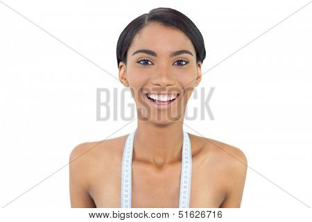 Pretty natural model with measuring tape on shoulders posing on white background