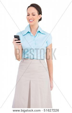 Smiling classy young businesswoman sending text message while posing on white background 