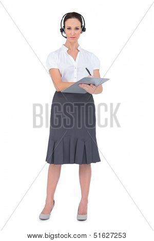 Pretty call center agent holding clipboard while posing on white background