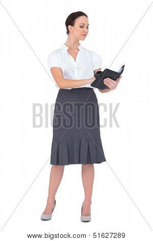 Focused businesswoman writing on her datebook on white background