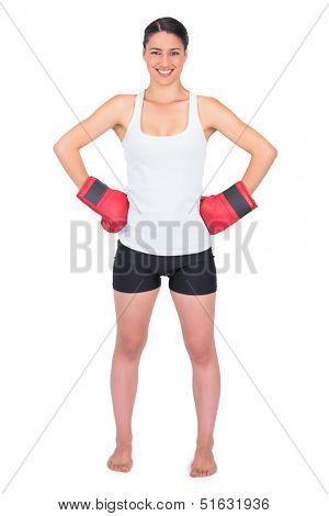 Smiling young model with boxing gloves posing on white background