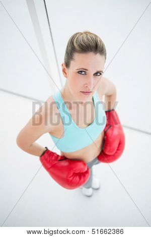 Serious woman wearing boxing gloves looking at camera