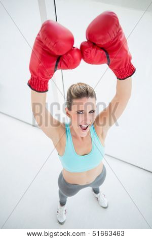 Woman with red boxing gloves arms up and screaming