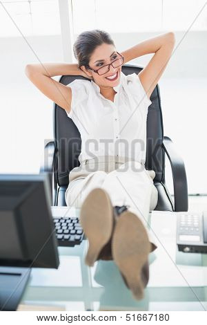 Reclining businesswoman sitting at her desk with her feet up in her office