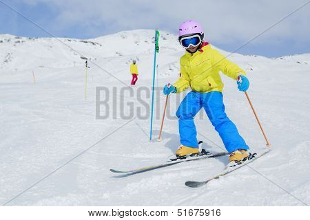 Skiing, skiers on ski run - child skiing downhill