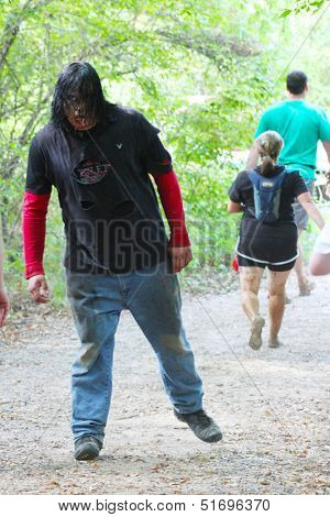 MUSKOGEE, OK - Sept. 14: Actors costumed as bloody zombies chase the athletes during the Castle Zombie Run at the Castle of Muskogee in Muskogee, OK on September 14, 2013. 