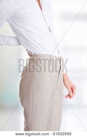 Woman with back pain holding her aching hip 