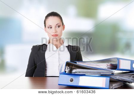 Sad woman with ringbinders sitting at the desk. Tired and exhousted business woman. 