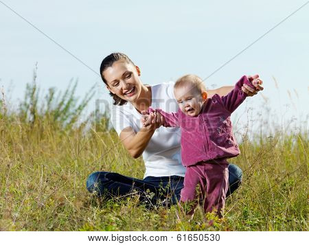 Happy young beautiful mather with smiling baby on nature outdoor